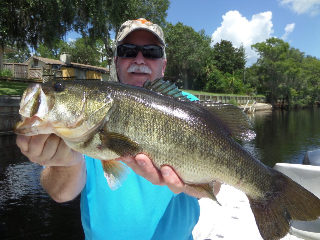 man in blue shirt holding fish