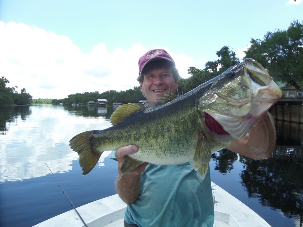 Man in hat on boat holding fish
