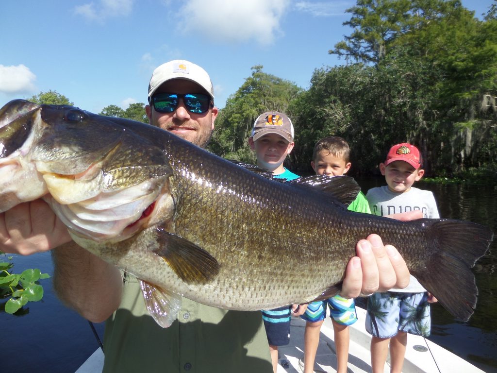 Man holding fish with kids in background