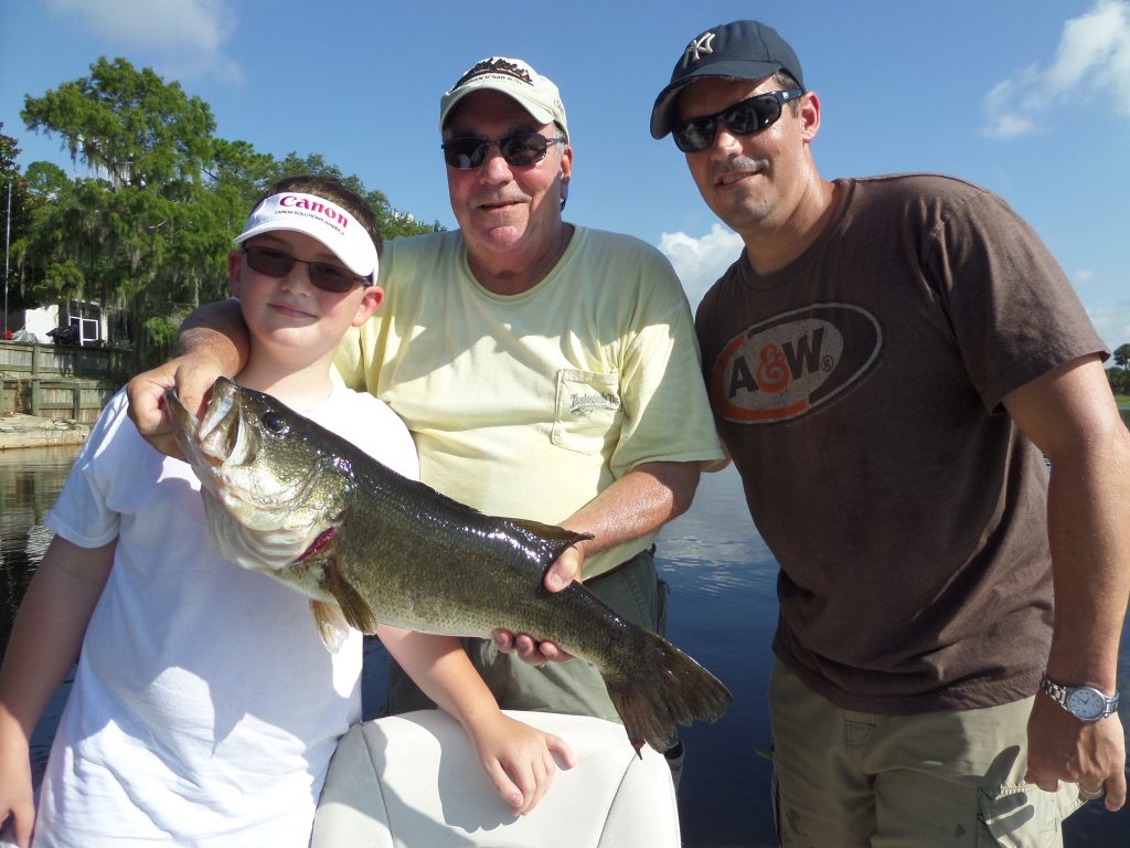 Men holding fish with boy